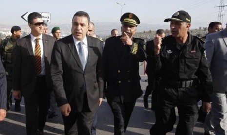 Tunisia's Prime Minister Mehdi Jomaa (front, in blue tie) inspects Tunisian police standing guard on the eve of presidential elections, in Beja November 22, 2014.