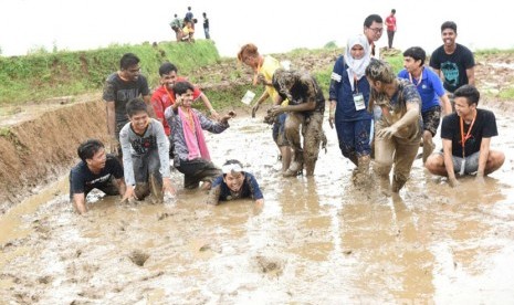 Turis asing dari 23 negara peserta Konferensi Desa se Dunia, asik bermain lumpur sawah bersama Bupati Purwakarta Dedi Mulyadi, di Kampung Tajur, Desa Pasanggrahan, Kecamatan Bojong, Purwakarta, Selasa (24/5).  (Republika/Ita Nina Winarsih)