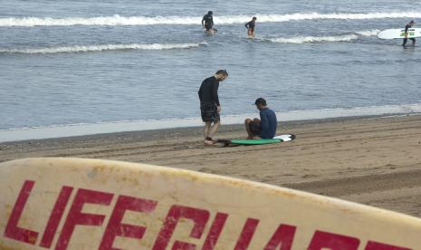 Turis asing mengunjungi pantai Kuta, Bali, Indonesia Selasa, 22 Maret 2022. Indonesia akan mencabut semua persyaratan karantina bagi pengunjung asing yang memasuki negara itu, kata menteri pariwisata, dua tahun setelah memberlakukan pembatasan perbatasan karena COVID-19.