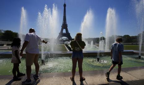 Turis berdiri di dekat Air Mancur Trocadero di sebelah Menara Eiffel, saat Eropa berada di bawah gelombang panas yang luar biasa ekstrem, di Paris, Prancis, Rabu, 3 Agustus 2022. Menteri keuangan Prancis Bruno Le Maire mengatakan bahwa dia khawatir tentang situasi ekonomi Inggris.