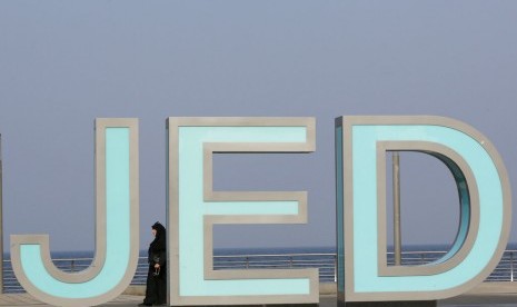 Turis berdiri di papan Jeddah Corniche di Jeddah, Arab Saudi. 