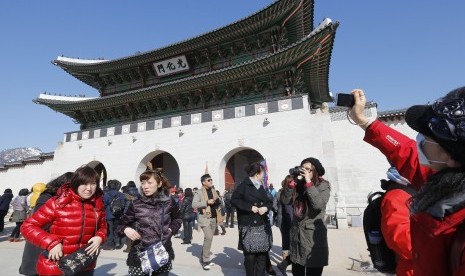 Wisata Korea. Turis berfoto dengan latar Istana Gyeongbok di Seoul, Korea.