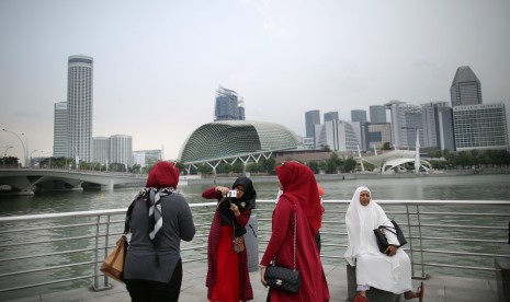 Turis berfoto di salah satu titik populer di Singapura.