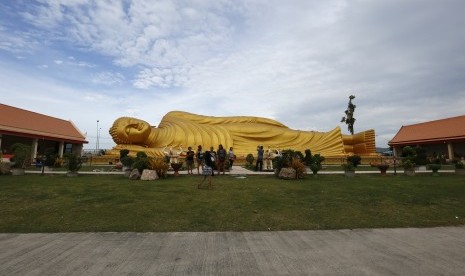 Turis menyaksikan patung 'Buddha Tidur' di kuil Wat Pho, Bangkok, Thailand. 