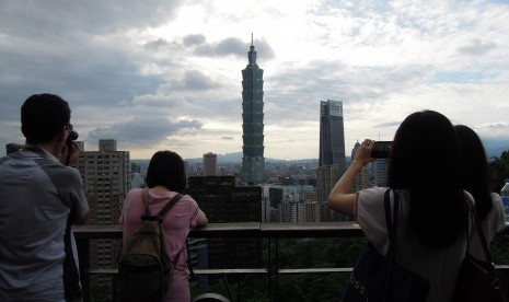 Turis sedang mengambil gambar bangunan paling ikonik Taiwan yakni Taipei 101.