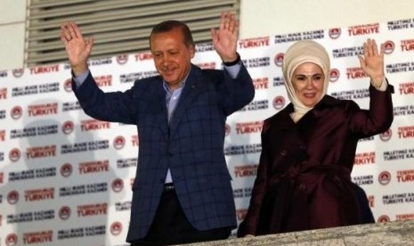 Turkey's Prime Minister Tayyip Erdogan and wife Ermine wave hands to supporters as they celebrate his election victory in front of the party headquarters in Ankara August 10, 2014.