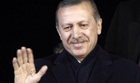 Turkey's Prime Minister Tayyip Erdogan greets his supporters upon arrival to Ataturk Airport in Istanbul December 27, 2013.