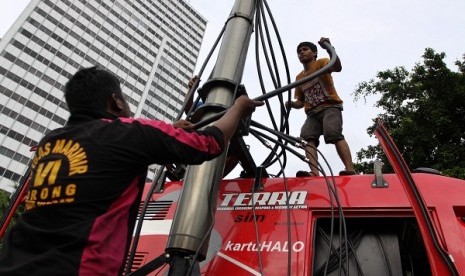 Two technicians install Base Transceiver Station (BTS) belongs to Telkomsel in Jakarta. Indonesian operators' signal is often too weak in border area, as happens in Pegudang village in Riau. (illustration)