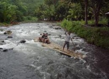 Two tourists enjoy their bamboo rafting as a jockey control the raft along Amandit River in South Kalimantan (photo file).