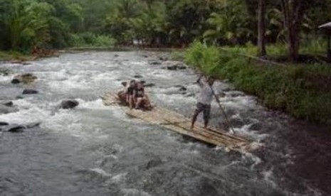 Two tourists enjoy their bamboo rafting as a jockey control the raft along Amandit River in South Kalimantan (photo file).