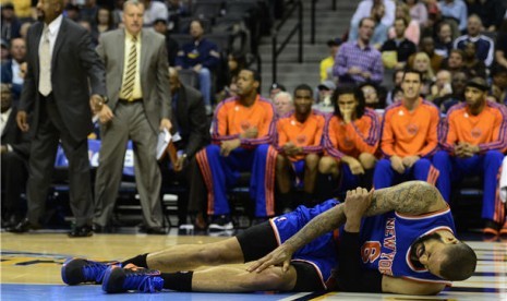 Tyson Chandler, pemain New York Knicks, tergeletak di lapangan saat menghadapi Denver Nuggets dalam laga NBA pada Rabu (13/3). 