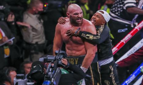 Tyson Fury dari Inggris (kiri) bereaksi dengan anggota timnya setelah mengalahkan Deontay Wilder dari AS dalam KO pada ronde ke-11 pertarungan gelar juara dunia kelas berat WBC di T-Mobile Arena di Las Vegas, Nevada, AS, 09 Oktober 2021. 