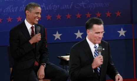 U.S. President Barack Obama laughs behind Republican presidential nominee Mitt Romney during the second U.S. presidential campaign debate in Hempstead, New York, October 16, 2012.   