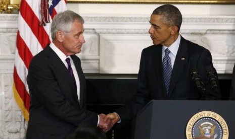 U.S. President Barack Obama (R) greets Defense Secretary Chuck Hagel after announcing Hagel's resignation at the White House in Washington, November 24, 2014. 