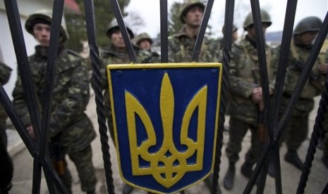 Ukrainian soldiers guard a gate to their military base in the village of Perevalne, outside of Simferopol, Ukraine, on Sunday, March 2, 2014.