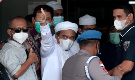  Ulama Indonesia dan pemimpin Front Pembela Islam (FPI) Rizieq Shihab (tengah), memberi isyarat kepada para pendukung saat ia tiba di Mabes Polri Jakarta, 12 Desember 2020. Habib Rizieq menghadapi penangkapan di Mabes Polri setelah meninggal dunia. bentrokan antara pendukungnya dan polisi minggu lalu, dan untuk mengatur pertemuan massal di tengah pandemi virus corona.