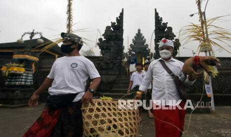 Umat Hindu melakukan ritual penyucian hewan kurban dalam rangkaian pujawali atau upacara persembahyangan di Pura Pasar Agung Besakih Giri Tohlangkir, Karangasem, Bali, Selasa (19/10/2021). Upacara persembahyangan di pura tersebut digelar pada 20-31 Oktober 2021 dan dibuka untuk masyarakat umum dengan menerapkan protokol kesehatan setelah sempat dilaksanakan secara terbatas hanya diikuti oleh pengurus pura pada tahun 2017 hingga 2020 akibat erupsi Gunung Agung dan pandemi COVID-19. 