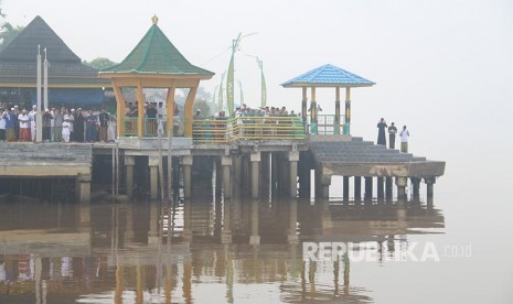 Muslims perform Eid al-Adha prayers on the banks of the Kapuas River in Pontianak, West Kalimantan, Sunday. Muslims in Pontianak perform Eid al-Adha prayers in a condition shrouded in thick haze from forest and land fires.