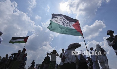 Participants of 115 rally raise Palestinian flags at National Monument (Monas) area, Central Jakarta, on Friday (May 11).