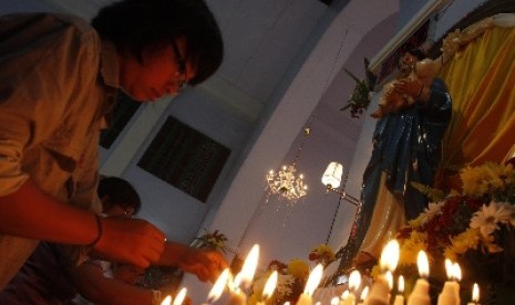 Umat Kristiani menyalakan lilin saat misa natal di Gereja Katolik Hati Kudus, Banda Aceh.