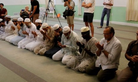 Umat Muslim berdoa bagi korban penembakan kelab gay di Orlando dengan dipimpin Imam Syed Shafeeq Rahman dari Islamic Center of Fort Pierce di Fort Pierce, Florida, Ahad, 12 Juni 2016.