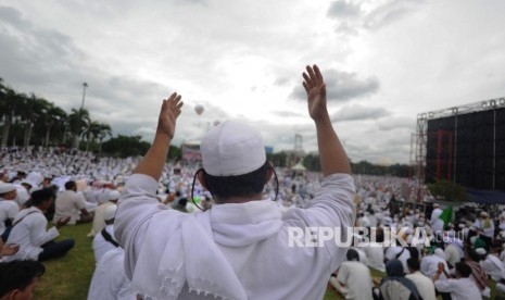 Umat muslim berdoa saat mengikuti aksi damai di kawasan Monas, Jakarta, Jumat (2/12)