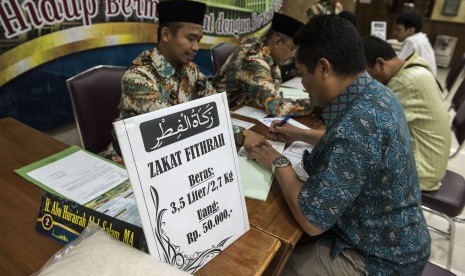 Umat muslim membayarkan zakat fitrah kepada panitia amil zakat (Ilustrasi)