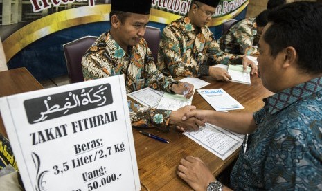 Umat muslim membayarkan zakat fitrah kepada panitia amil zakat di masjid (Ilustrasi)