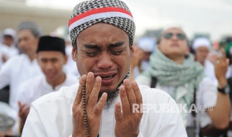 Umat muslim menangis saat berdoa di acara aksi damai di kawasan Monas, Jakarta, Jumat (2/12).