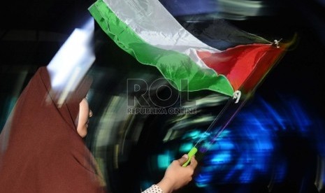 Umat muslim mengibarkan bendera saat mengikuti hari perayaan Palestine Solidarity Day (PSD) di Istora Senayan, Jakarta, Ahad (29/11). PSD merupakan peringatan sekaligus penolakan masyarakat atas tragedi pembagian Palestina berdasarkan PBB no 181, yang teru