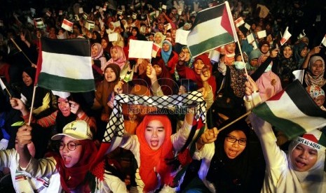 Umat muslim mengibarkan bendera saat mengikuti hari perayaan Palestine Solidarity Day (PSD) di Istora Senayan, Jakarta, Ahad (29/11).