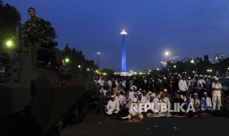 Umat muslim seusai menunaikan solat magrib di monas, Jakarta, Jumat (4/11)