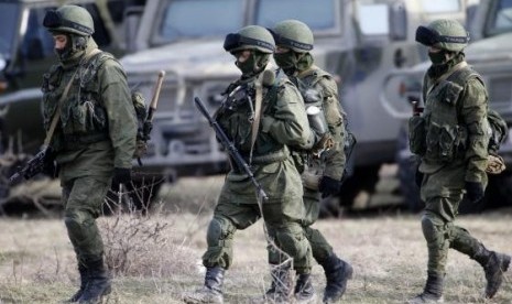 Uniformed men, believed to be Russian servicemen, walk near a Ukrainian military base in the village of Perevalnoye, outside Simferopol, March 6, 2014.