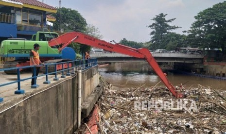 UPK Badan Air Dinas Lingkungan Hidup DKI Jakarta menangani sampah yang menumpuk di Pintu Air Manggarai, Jakarta Pusat, Senin (12/11).