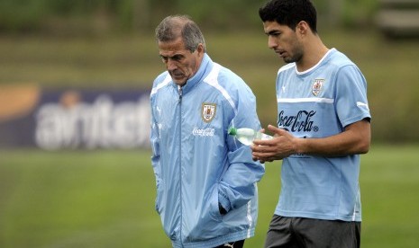 Uruguay coach Oscar Tabarez, left, and striker Luis Suarez walk together on the pitch after a training session on the outskirts of Montevideo, Tuesday, Oct. 9, 2012. Uruguay will face Argentina in a World Cup 2014 qualifying soccer game on Friday.