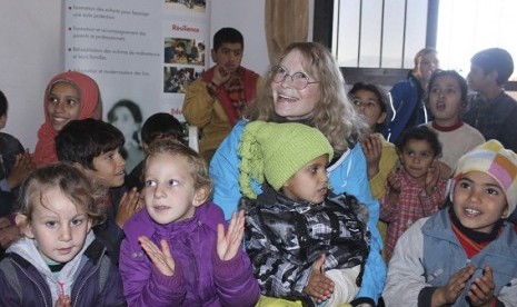 Aktris Mia Farrow (tengah) yang merupakan UNICEF goodwill ambassador berada di antara anak-anak pengungsi Suriah di kantor UNICEF, Wadi Khaled, utara Lebanon, 14 Januari 2013. Farrow merupakan penyintas polio.