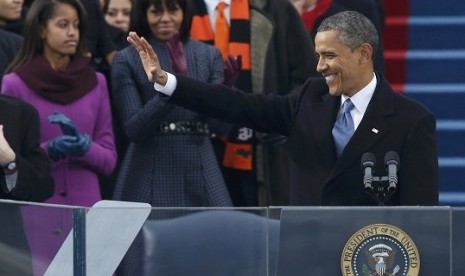 US first lady Michelle Obama applauds and daughter Malia (left) looks on as US President Barack Obama delivers his inaugural address after he took the oath of office during swearing-in ceremonies on the West Front of the U.S. Capitol in Washington, January