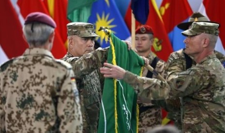    US General John Campbell (center), commander of NATO-led International Security Assistance Force (ISAF), folds the flag of the ISAF during the change of mission ceremony in Kabul, December 28, 2014. 