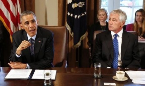 US President Barack Obama (left) speaks as Secretary of Defense Chuck Hagel listens before the start of a Cabinet Meeting in the Cabinet Room at the White House in Washington, November 7, 2014.