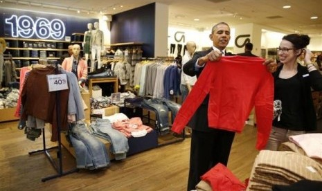 US President Barack Obama looks for gifts for his family with salesperson Susan Panariello after stopping off at the GAP in New York, March 11, 2014.