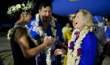 US Secretary of State Hillary Rodham Clinton, right, reacts as she attends an arrival ceremony at Rarotonga International Airport in Rarotonga, Cook Islands, Thursday, Aug. 30, 2012. Clinton arrived Thursday in the South Pacific at the top of a six-nation 