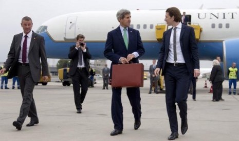 US Secretary of State John Kerry (center) walks to his car with Austria's Foreign Minister Sebastian Kurz (right) as he arrives at Vienna International Airport, in Vienna October 15, 2014.