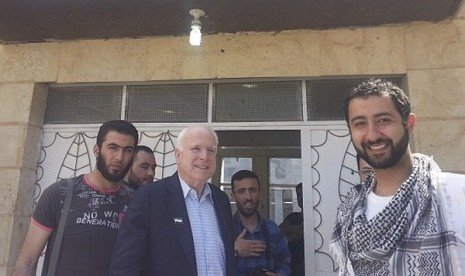 US Senator John McCain (middle), an outspoken advocate for US military aid to the Syrian opposition, meets with Free Syrian Army fighters and SETF Executive Director Mouaz Moustafa (right) during a surprise visit to Syria in this May 27, 2013 handout photo