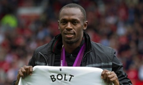 Usain Bolt memegang jersey Manchester United bertuliskan namanya