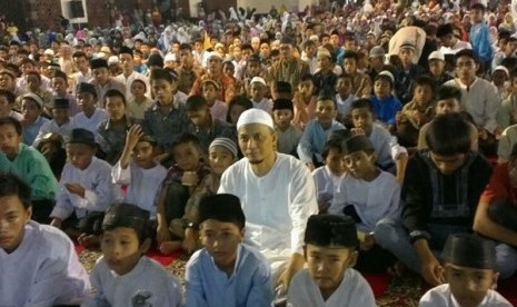 Ustad Muhammad Arifin Ilham duduk bersama anak anak yatim piatu di mesjid Raya Sumatra Barat.