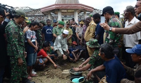 Ustadz Ali Muchtar sebagai pemuka Agama Islam di Tolikara meletakan batu pertama untuk pembangunan kembali kios yang terbakar di Tolikara, Kamis (23/7). 