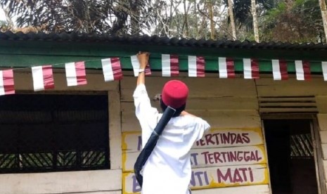 Ustaz Abdul Somad memasang bendera merah putih di rumah di permukiman Suku Talang Mamak, pedalaman Riau.