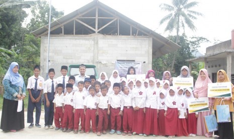 Ustaz dan ustazah bersama siswa sekolah madrasah.