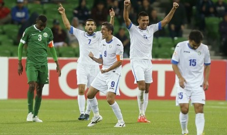 Uzbekistan's players celebrate after winning their Asian Cup Group B soccer match against Saudi Arabia at the Rectangular stadium in Melbourne January 18, 2015