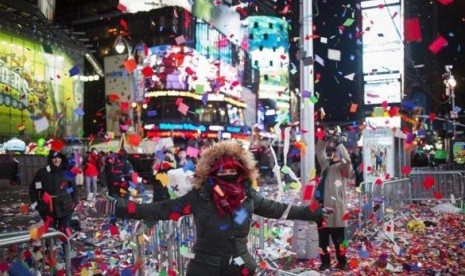 Valentina Guazzolini, of Ravenna, Italy, plays in confetti which was scattered by a gust of wind into the air after New Year celebrations in Times Square, Midtown, New York January 1, 2014. 